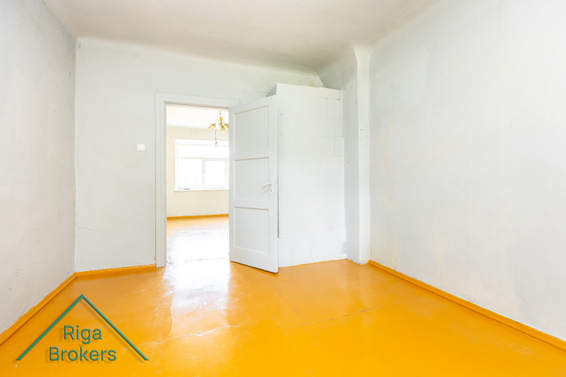 Simple room with a yellow floor and a white door.