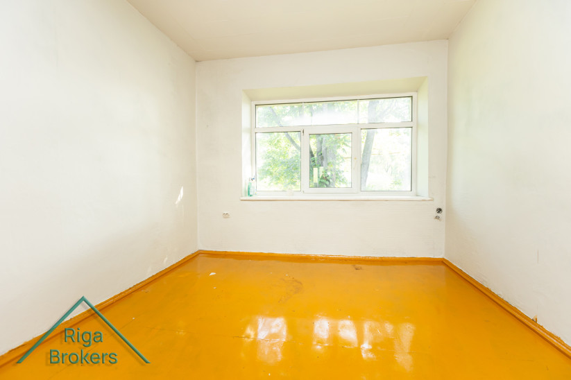 Bright room with a large window and yellow floor.