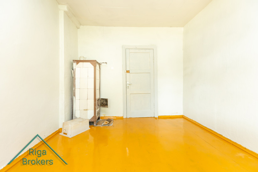 Room with a white door and tiled stove.