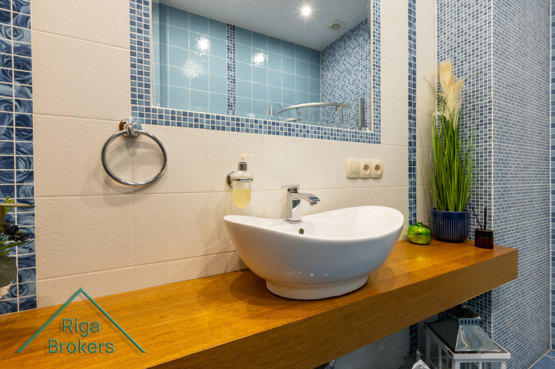 White sink on wooden counter in bathroom.