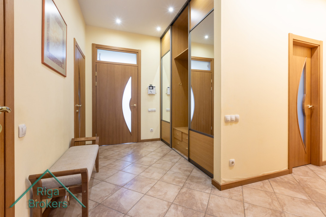 Spacious hallway with mirrored cabinets.