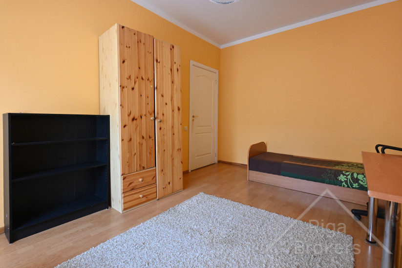 Guļamistaba ar gaišām sienām un skapi.