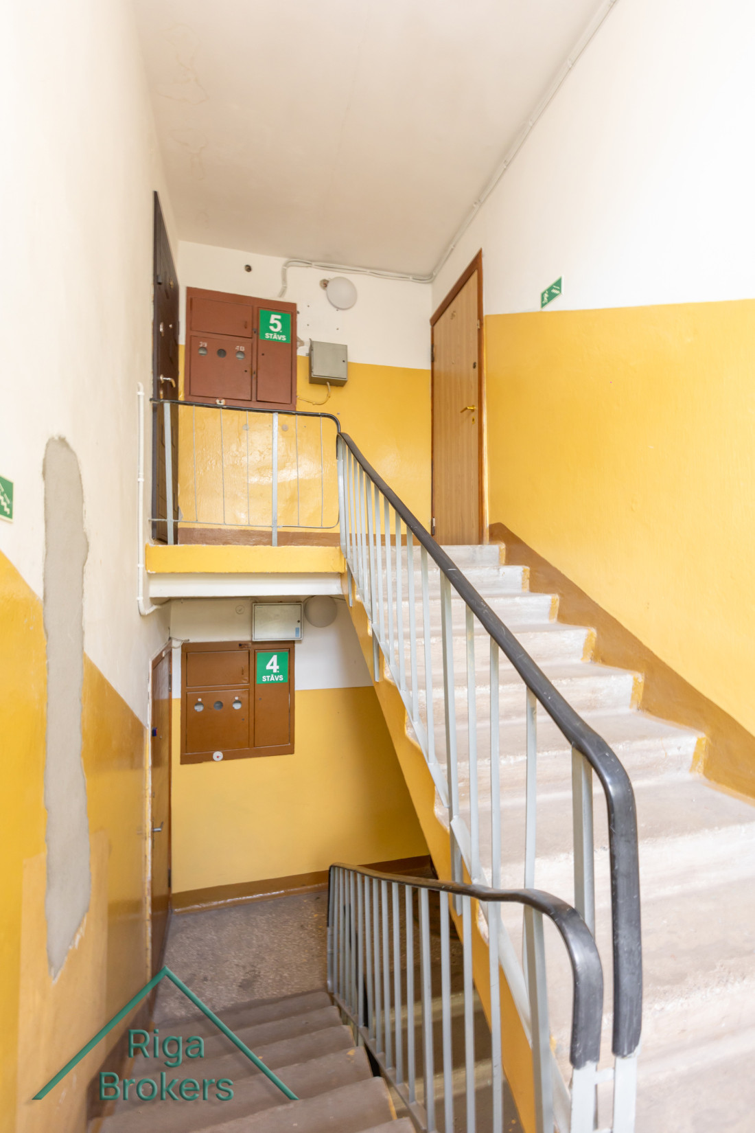 Staircase with yellow walls and signs.