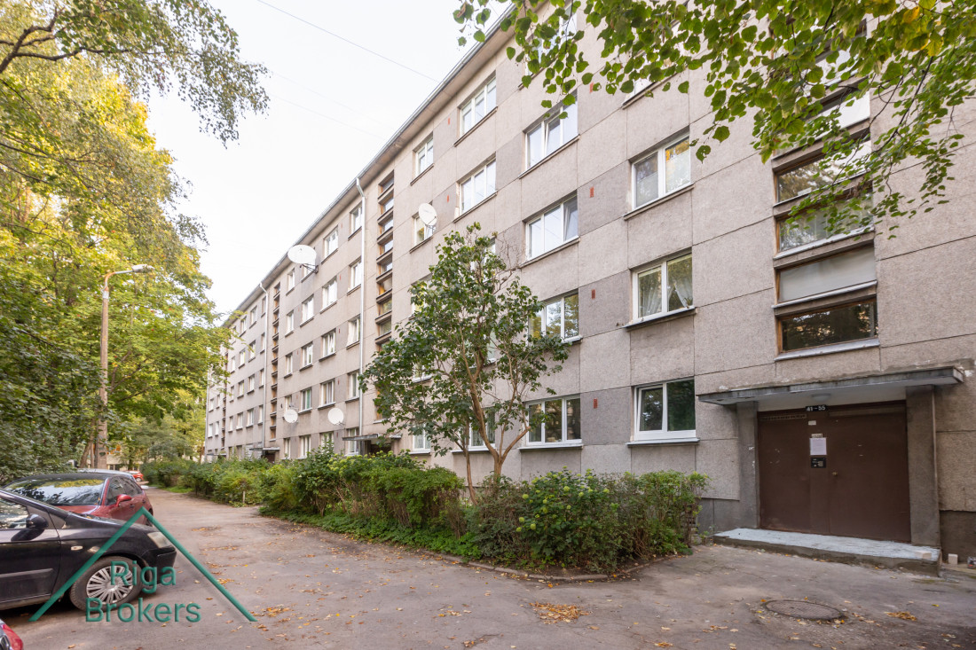 Apartment building with greenery around.