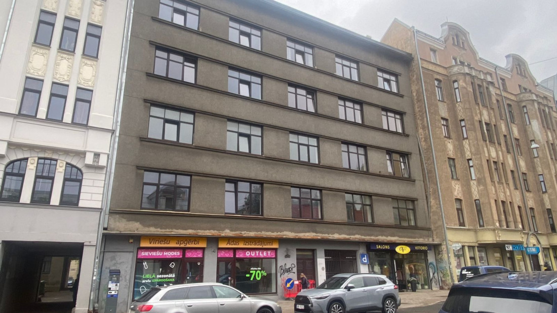 Multi-story building with gray facade.