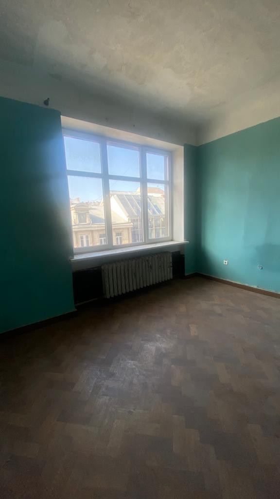 Room with large window and radiator.