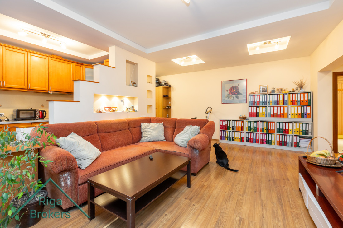 Living area with a large sofa and shelves.