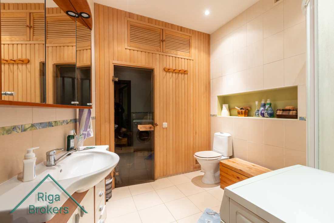Bathroom with sauna door and sink.