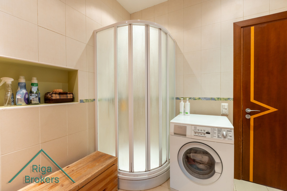 Bathroom with shower cabin and washing machine.