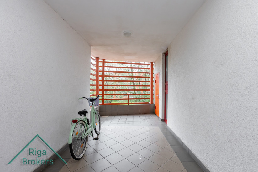 Open loggia with a bicycle and wooden details.