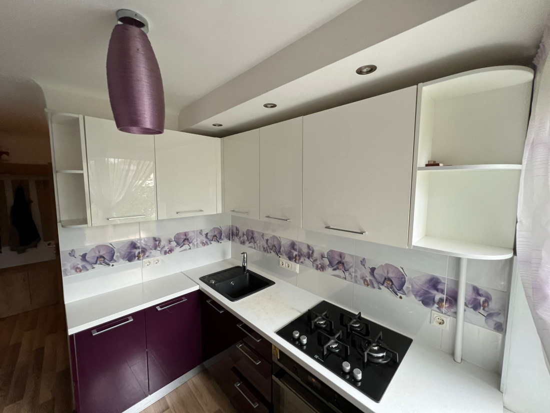 Kitchen with gas stove and window.
