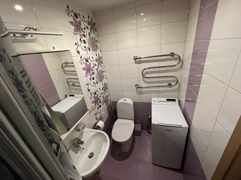 Small bathroom with washing machine.