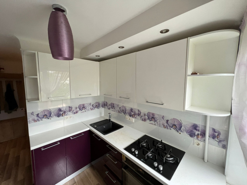 Kitchen with gas stove and window.