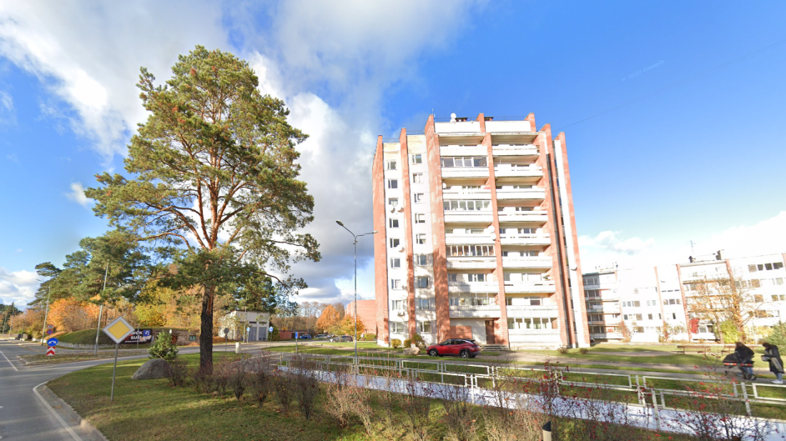 Apartment building with pines in the foreground.