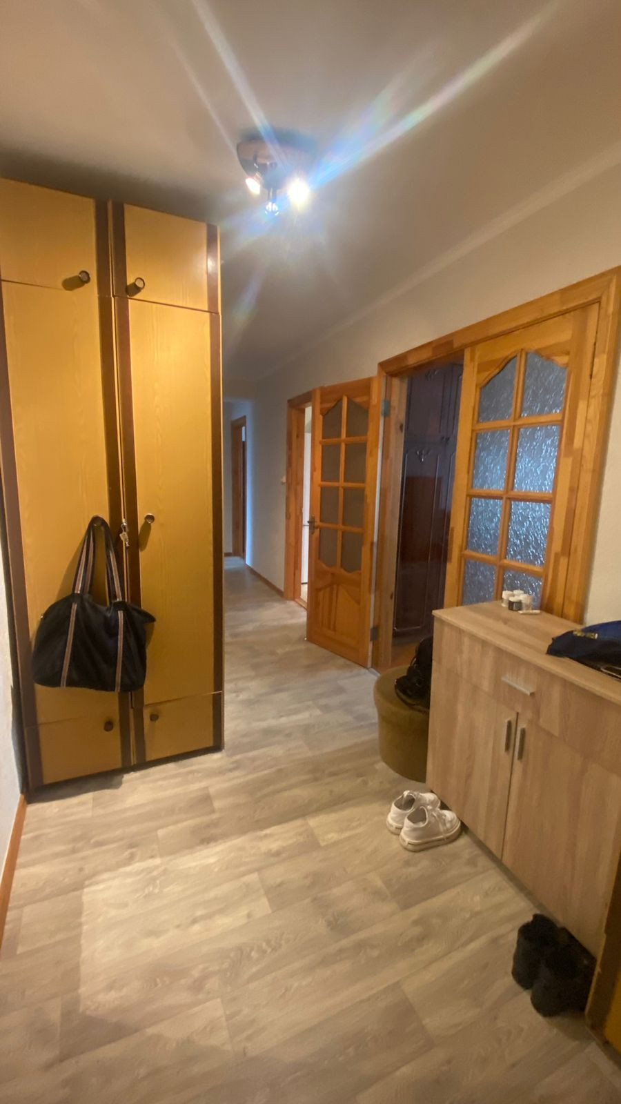 Corridor with wooden cabinets and shoes.