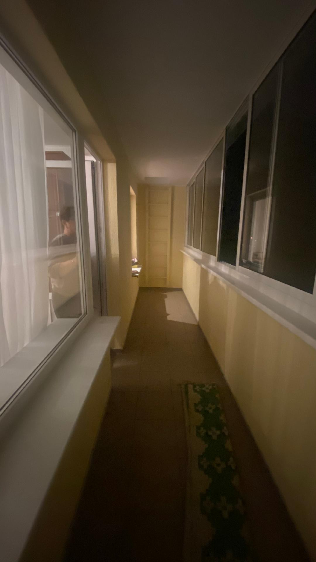 Long enclosed balcony with windows.