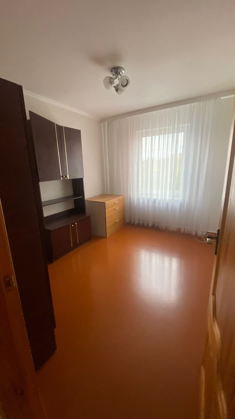 Room with a desk and curtains.