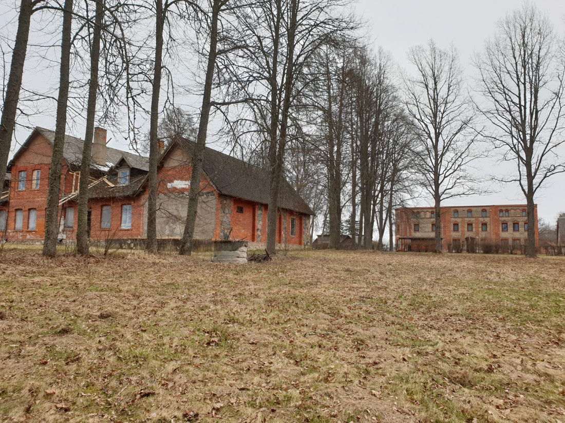 Māju ieskauj koki