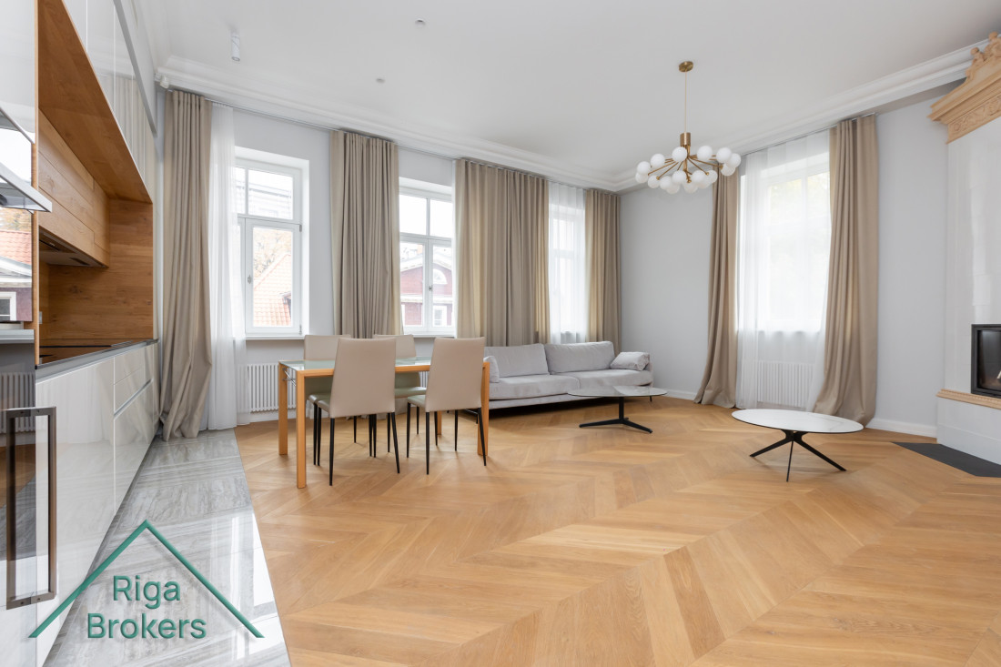 Spacious living room with large windows and a table.