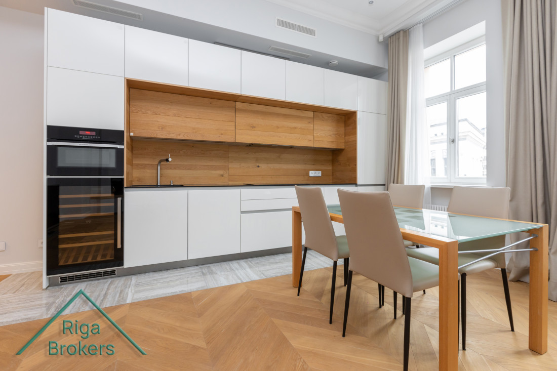 Modern kitchen with glass table and chairs.