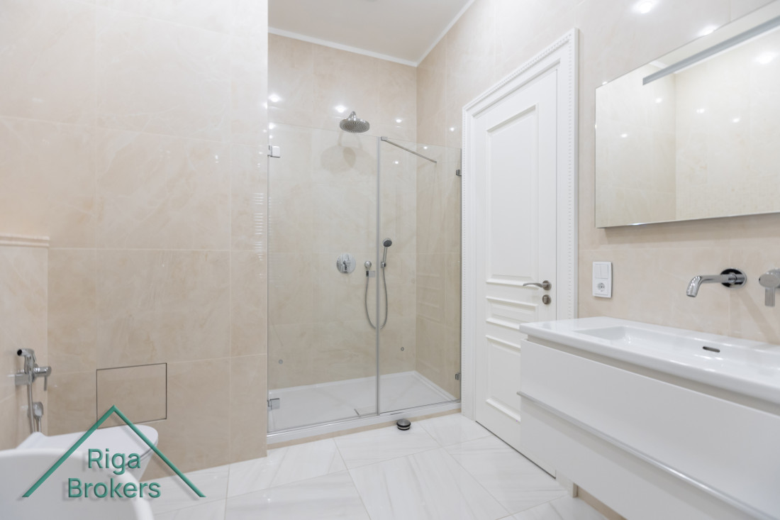 Modern bathroom with shower cabin and mirror.