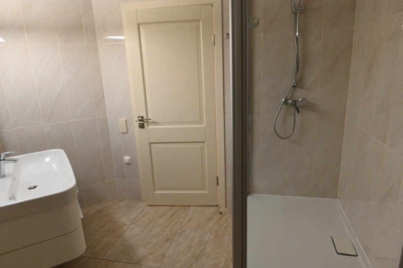 Vannas istaba ar dušu un flīzēm.