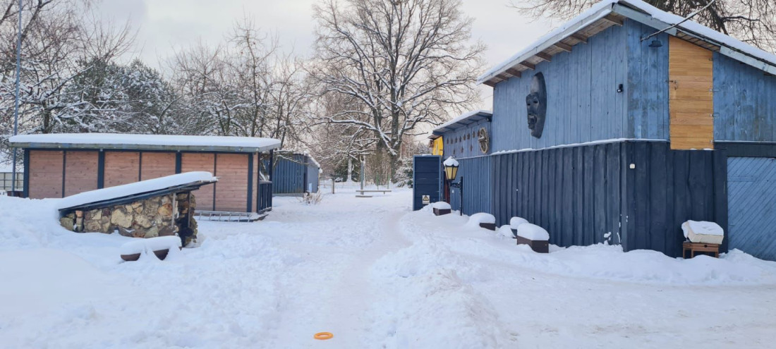 Snowy yard with wooden structures.