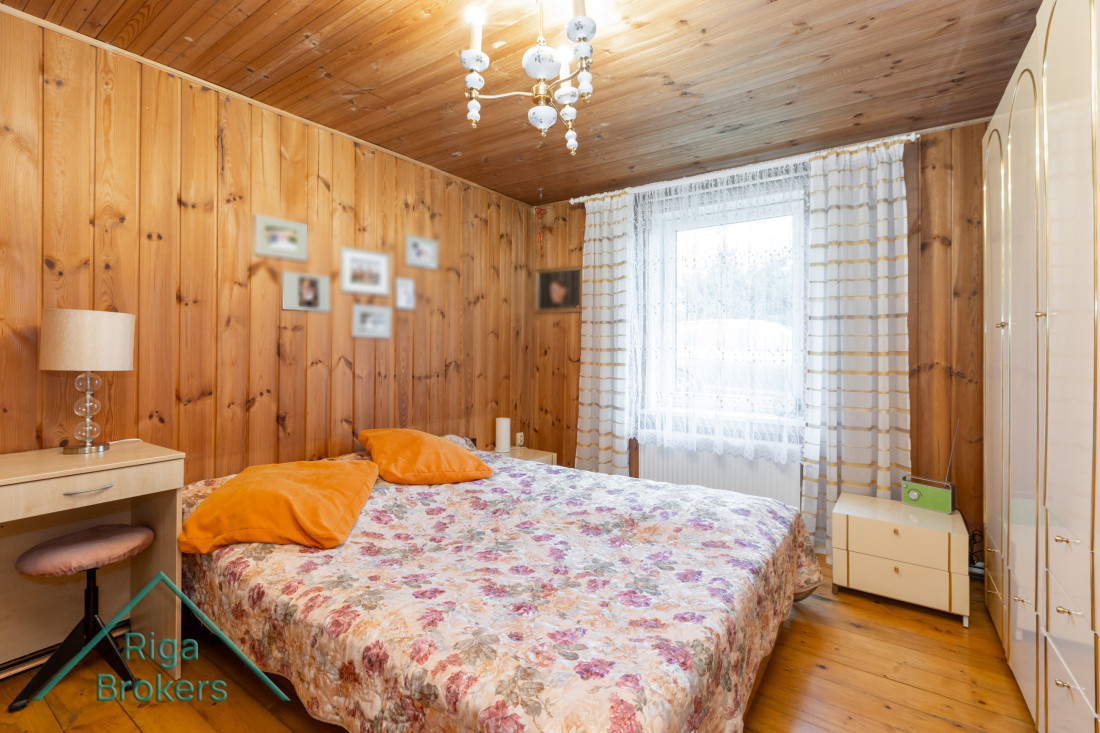 Bedroom with wooden walls and a bed.