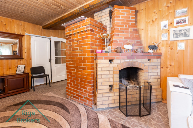 Brick-finished fireplace with wooden ceiling.