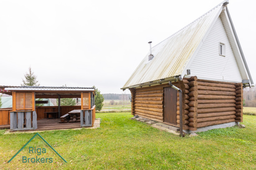 Wooden house with bar and green meadow.