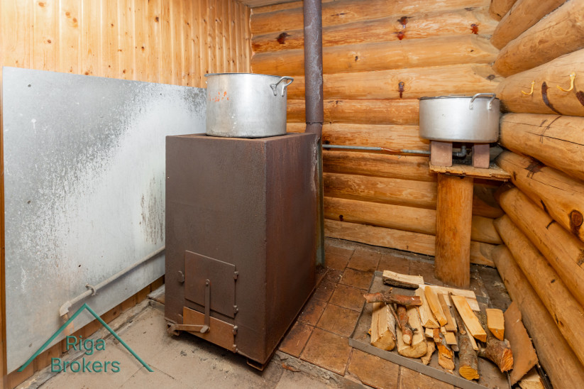 Wood-burning stove inside a rustic sauna.