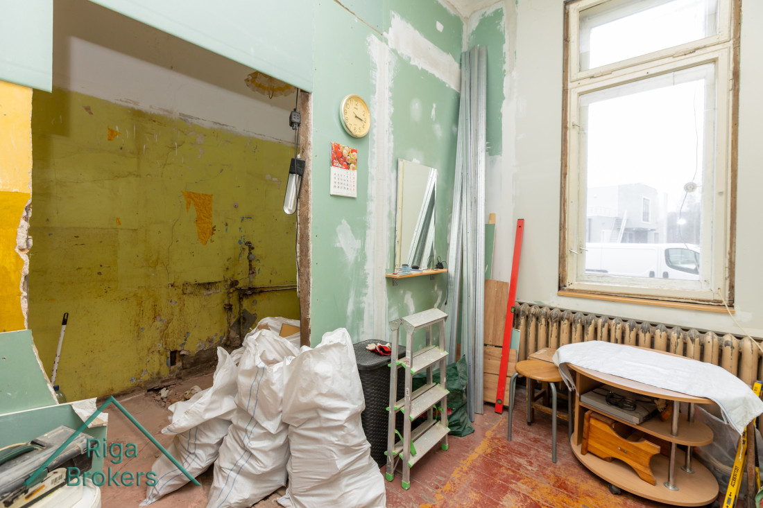 Room with construction materials and radiator.