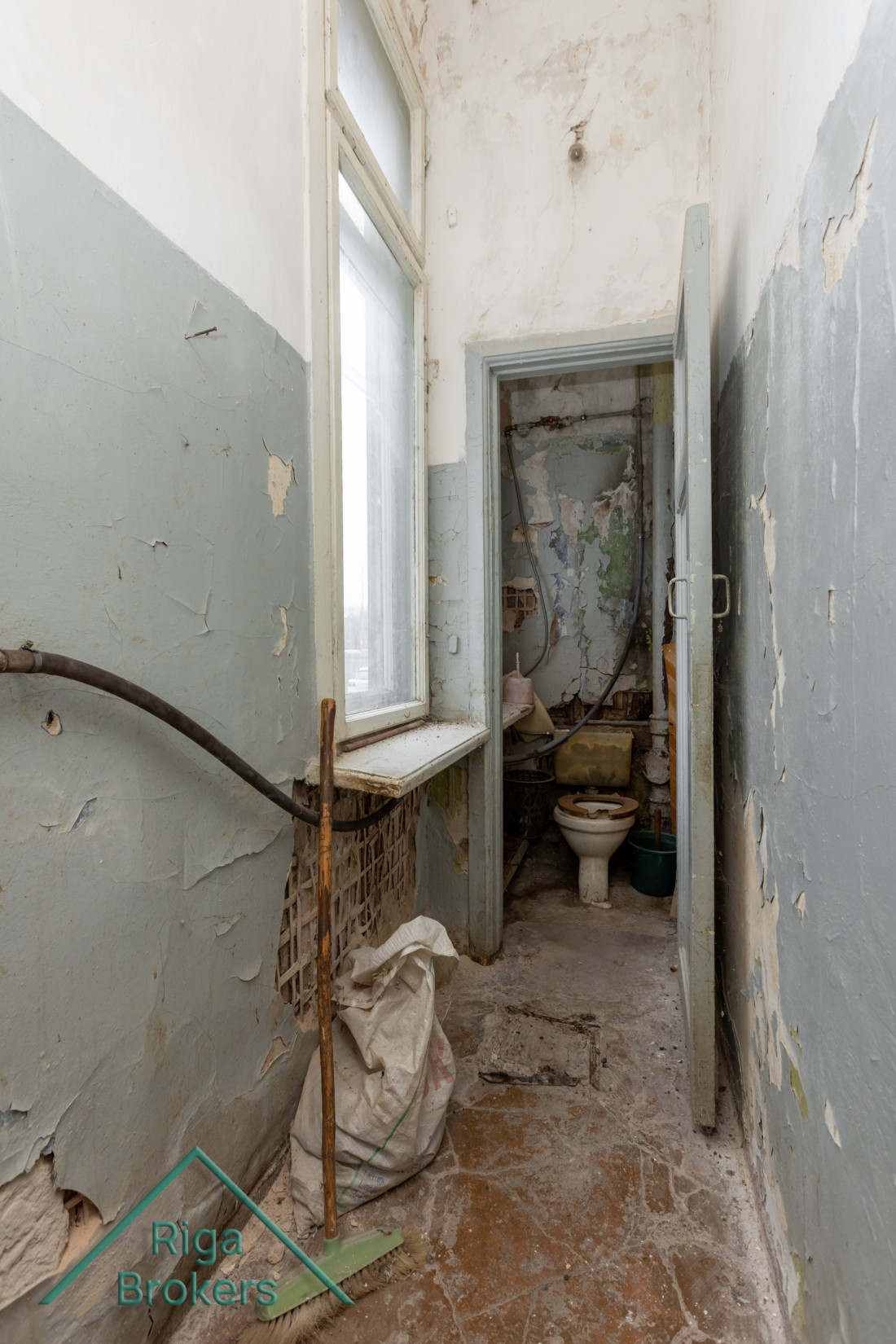 Deteriorated restroom with a window.