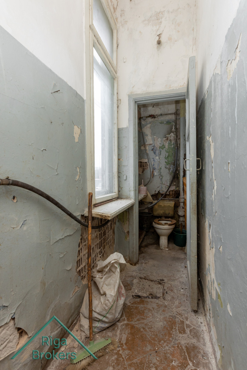 Deteriorated restroom with a window.