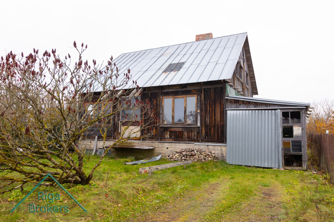  koka māja ar metāla jumtu.
