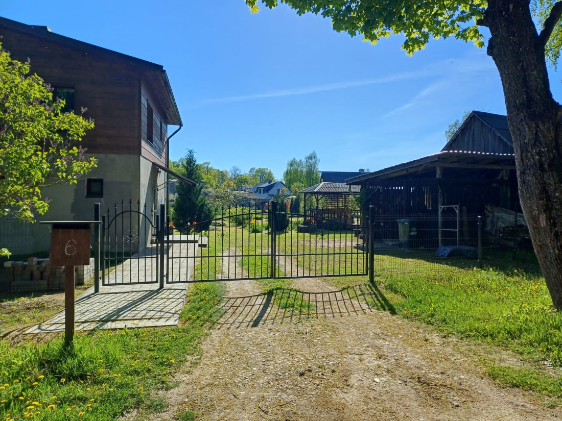  Divstāvu mājas aizmugure ar skatu uz dārzu. 