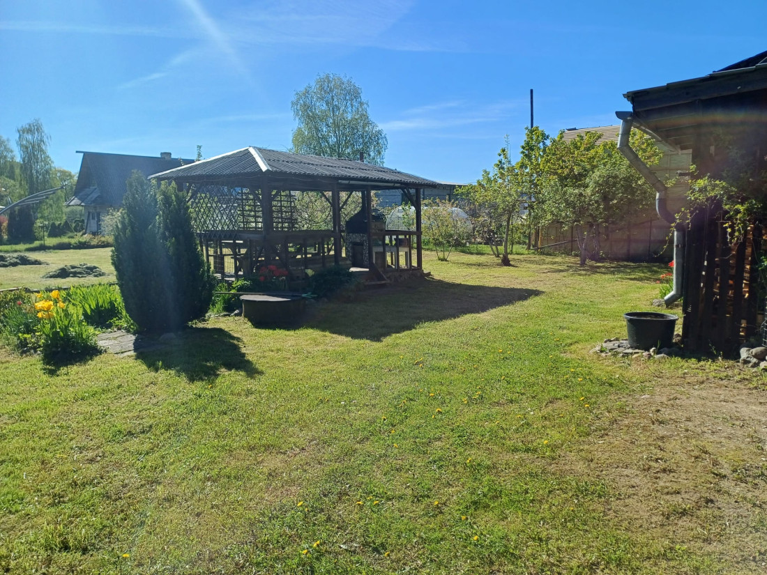 Divstāvu māja ar pergolu un labiekārtotu dārzu.