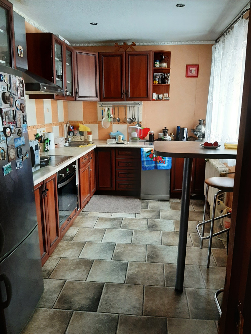 Virtuve ar rozā skapjiem un logu.