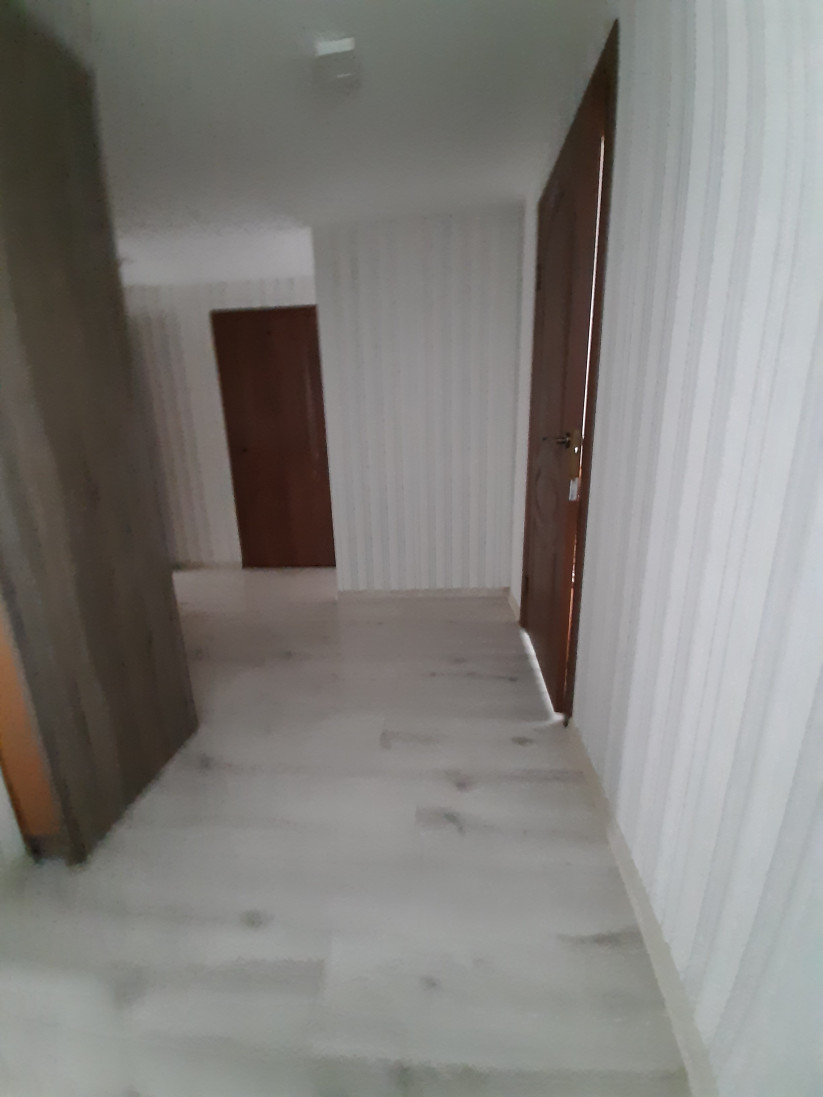 Tumšs, taisns koridors ar baltām sienām