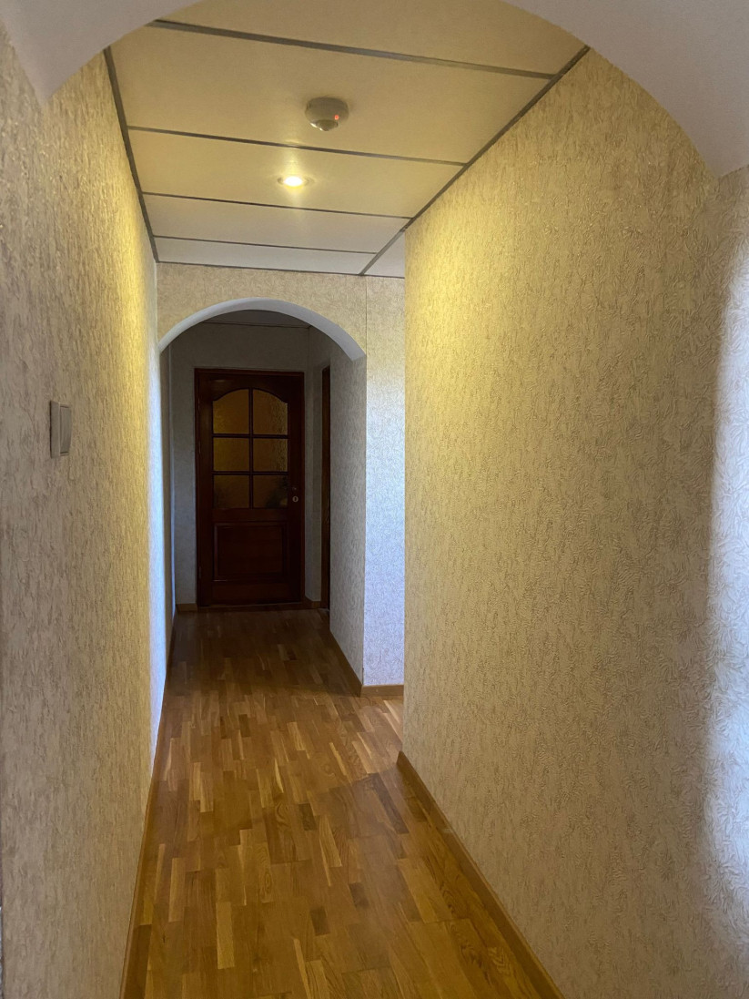 Koridors ar zaļām durvīm un gaišām sienām
