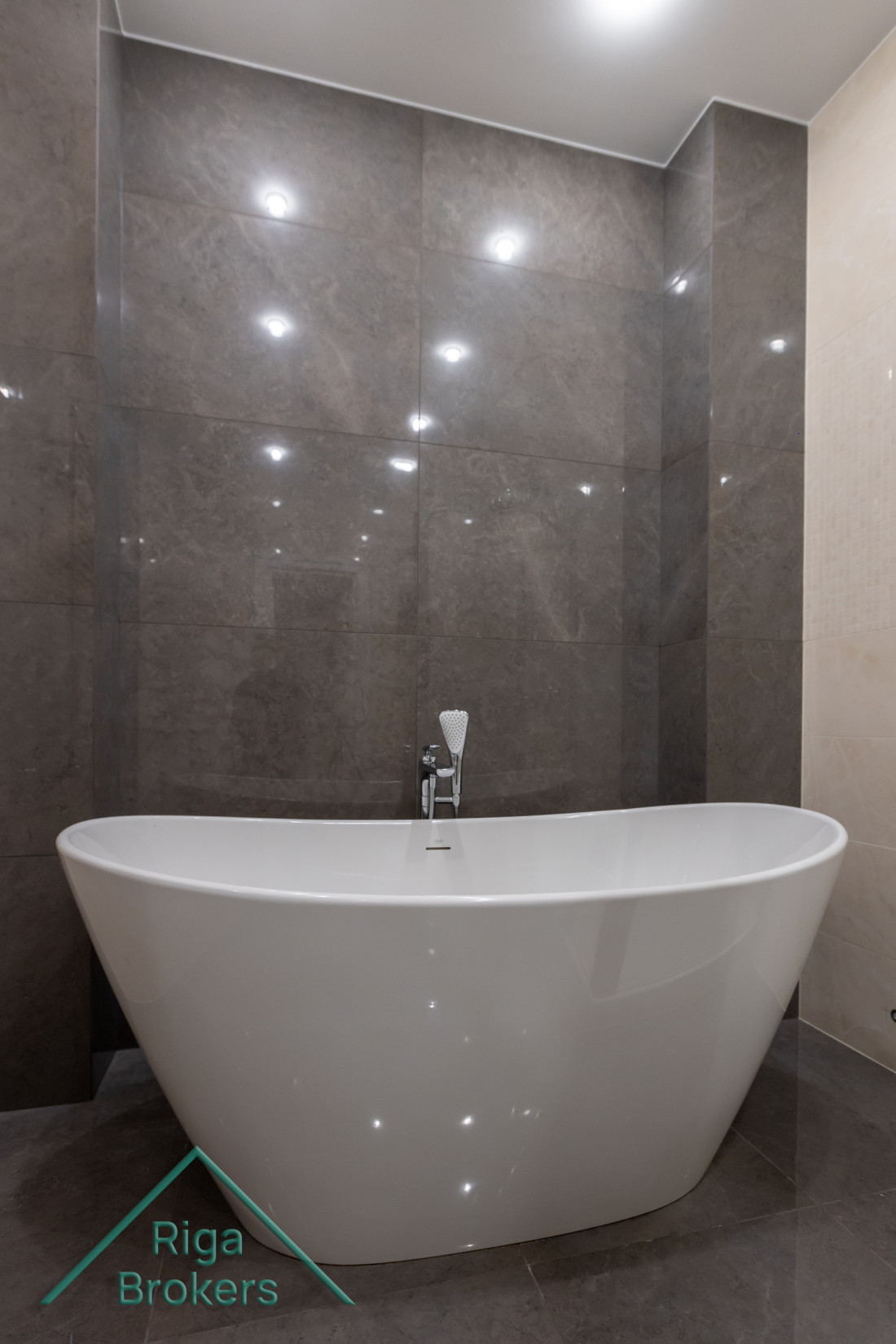 Elegant white tub on marble floor.
