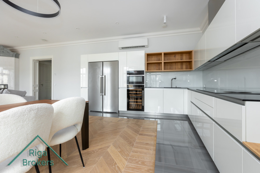 Modern kitchen area with white cabinets.