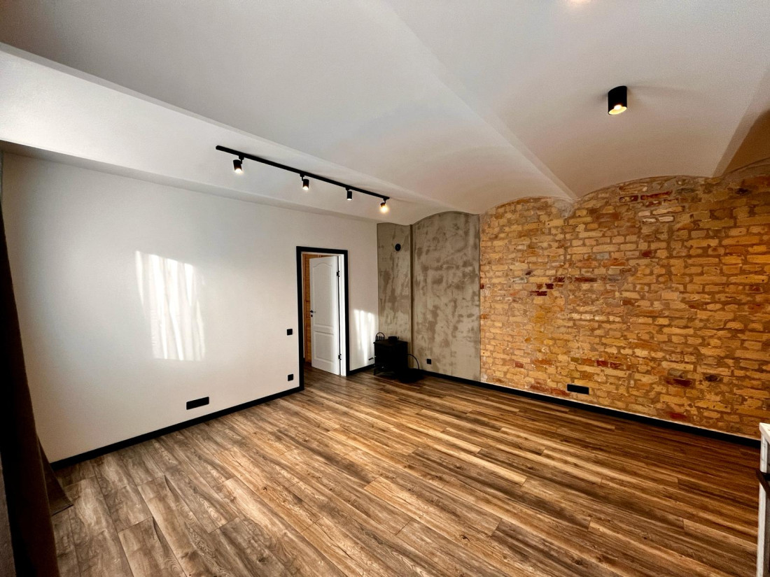Modern room interior with wooden floors and brick walls.