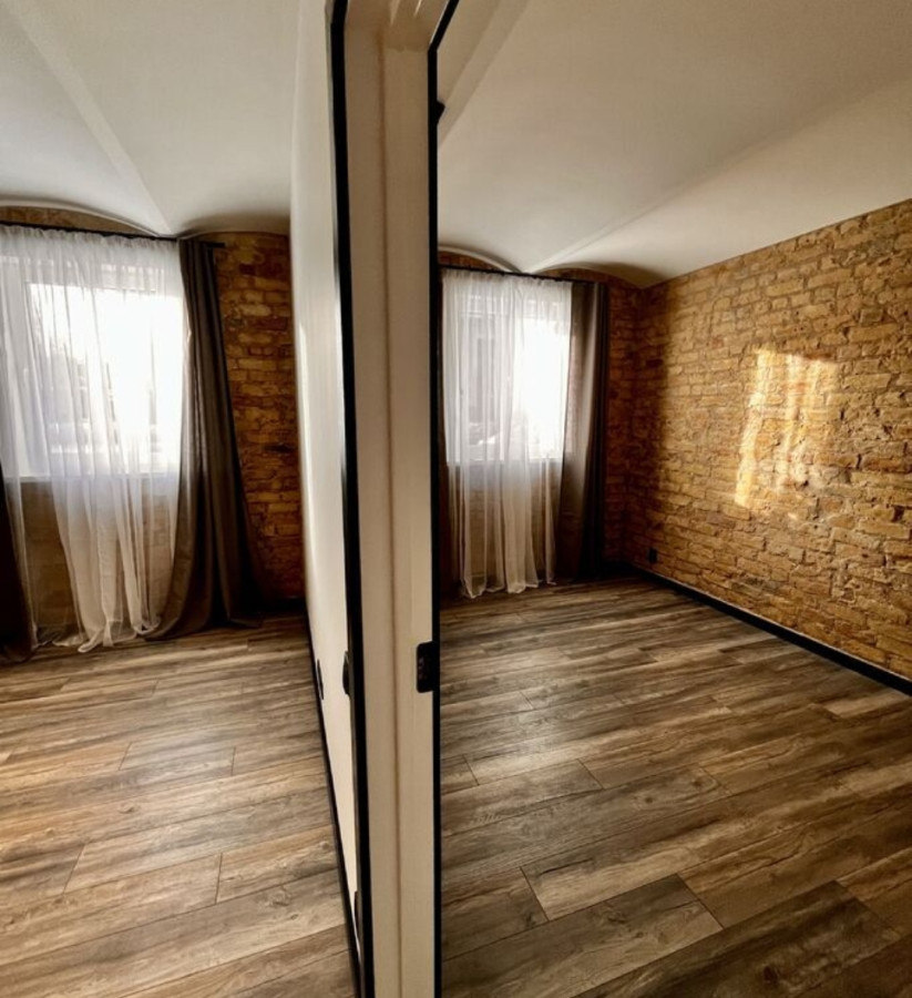 View of the kitchen from the living room with masonry walls.
