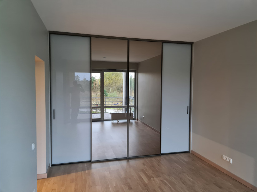 Bedroom interior with closets and a balcony.