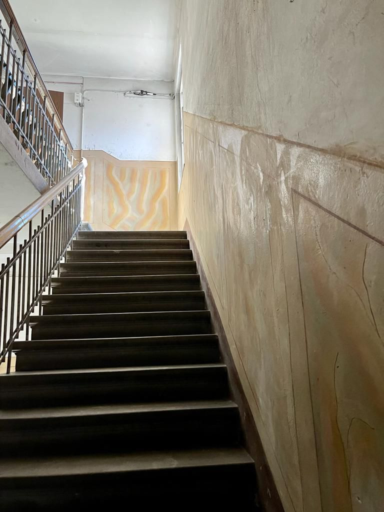 Stairwell with wooden railings and wall decor.