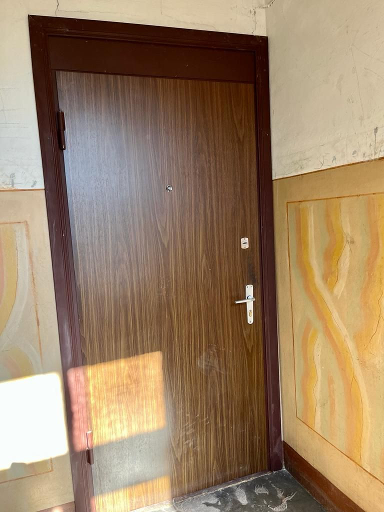 Interior door with wooden finish and handle.