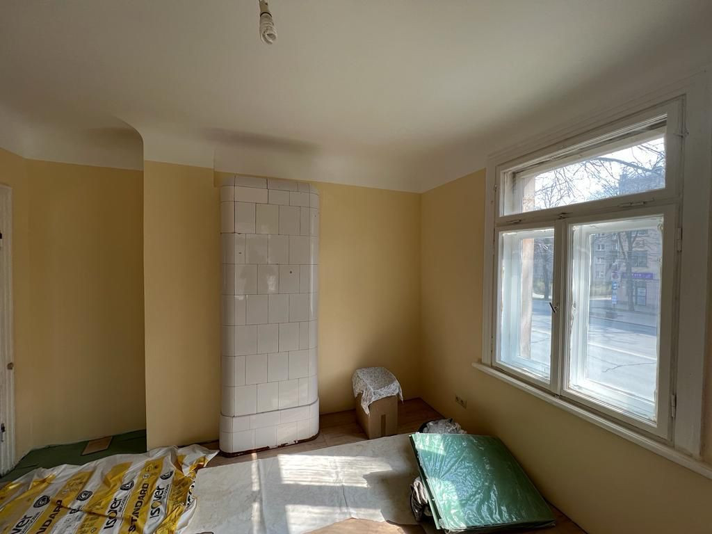 Room with a large window and a stove.