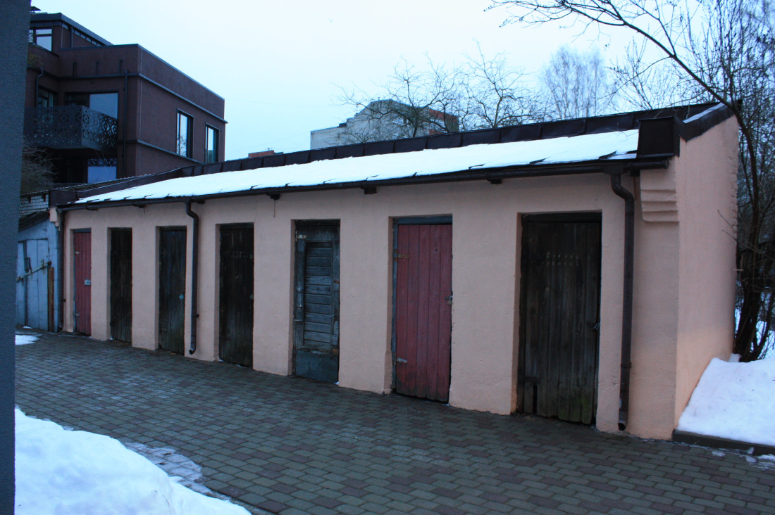 Old garages with different colored doors.