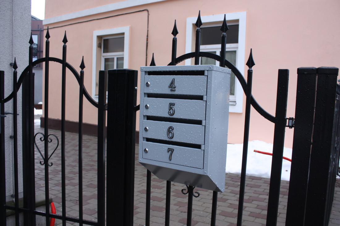 Mailboxes by iron gate.